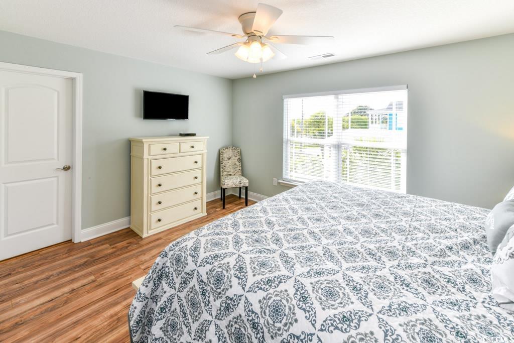 1614 North Ocean Boulevard Surfside Beach, SC 29575 - Photo 17 of 38 Bedroom with a ceiling fan, wood finished floors, visible vents, and baseboards