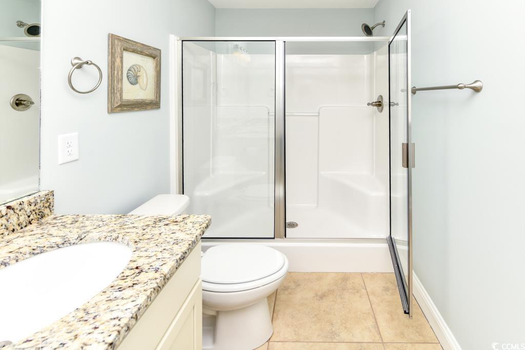 1614 North Ocean Boulevard Surfside Beach, SC 29575 - Photo 23 of 38 Full bath with tile patterned flooring, toilet, vanity, and a shower with door