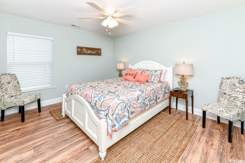 1614 North Ocean Boulevard Surfside Beach, SC 29575 - Photo 24 of 38 Bedroom featuring visible vents, a ceiling fan, baseboards, and wood finished floors