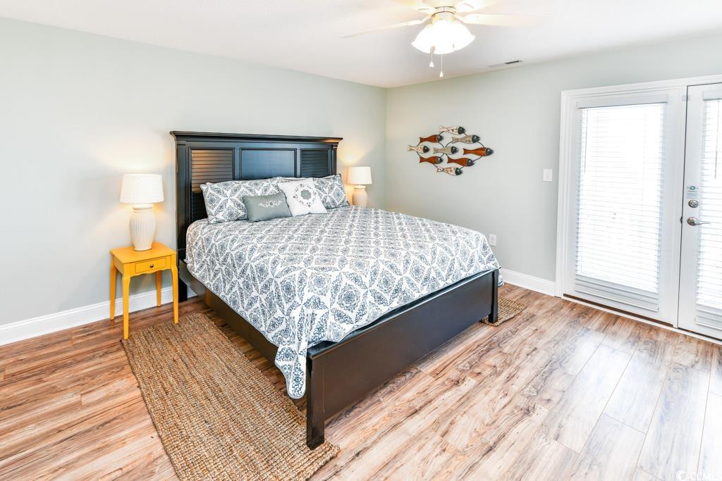 1614 North Ocean Boulevard Surfside Beach, SC 29575 - Photo 28 of 38 Bedroom featuring access to outside, multiple windows, light wood-style floors, and baseboards
