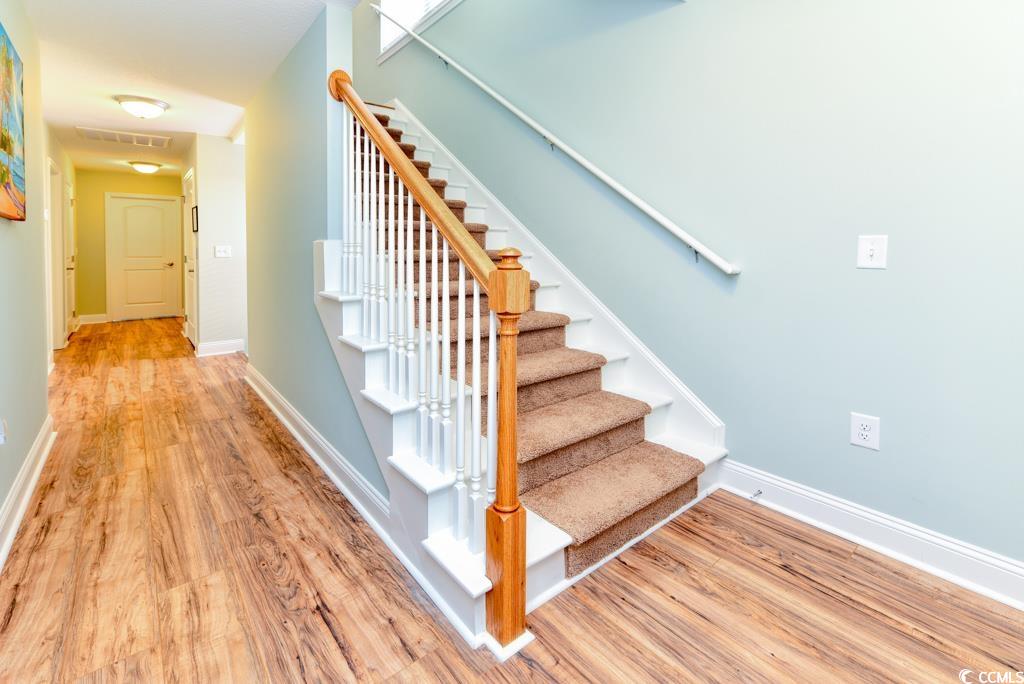 1614 North Ocean Boulevard Surfside Beach, SC 29575 - Photo 32 of 38 Stairs with visible vents, baseboards, and wood finished floors