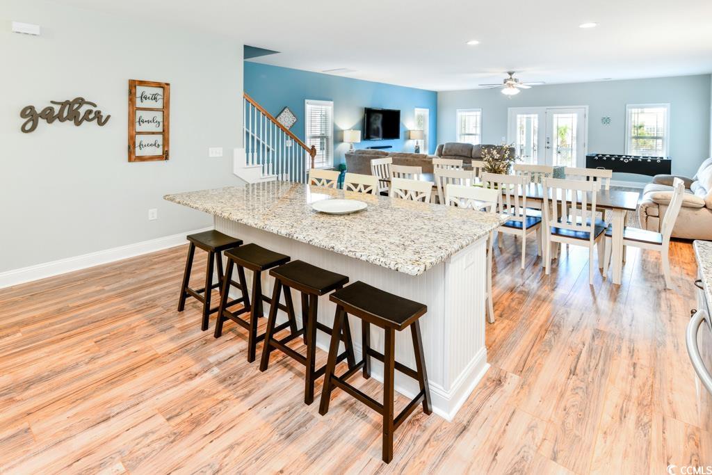 1614 North Ocean Boulevard Surfside Beach, SC 29575 - Photo 38 of 38 Kitchen featuring a kitchen island, baseboards, open floor plan, a kitchen breakfast bar, and light wood-style floors