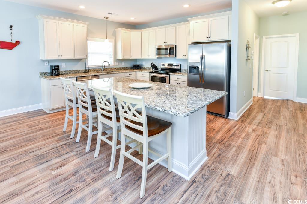 1614 North Ocean Boulevard Surfside Beach, SC 29575 - Photo 4 of 38 Kitchen featuring a breakfast bar area, baseboards, a kitchen island, a sink, and appliances with stainless steel finishes