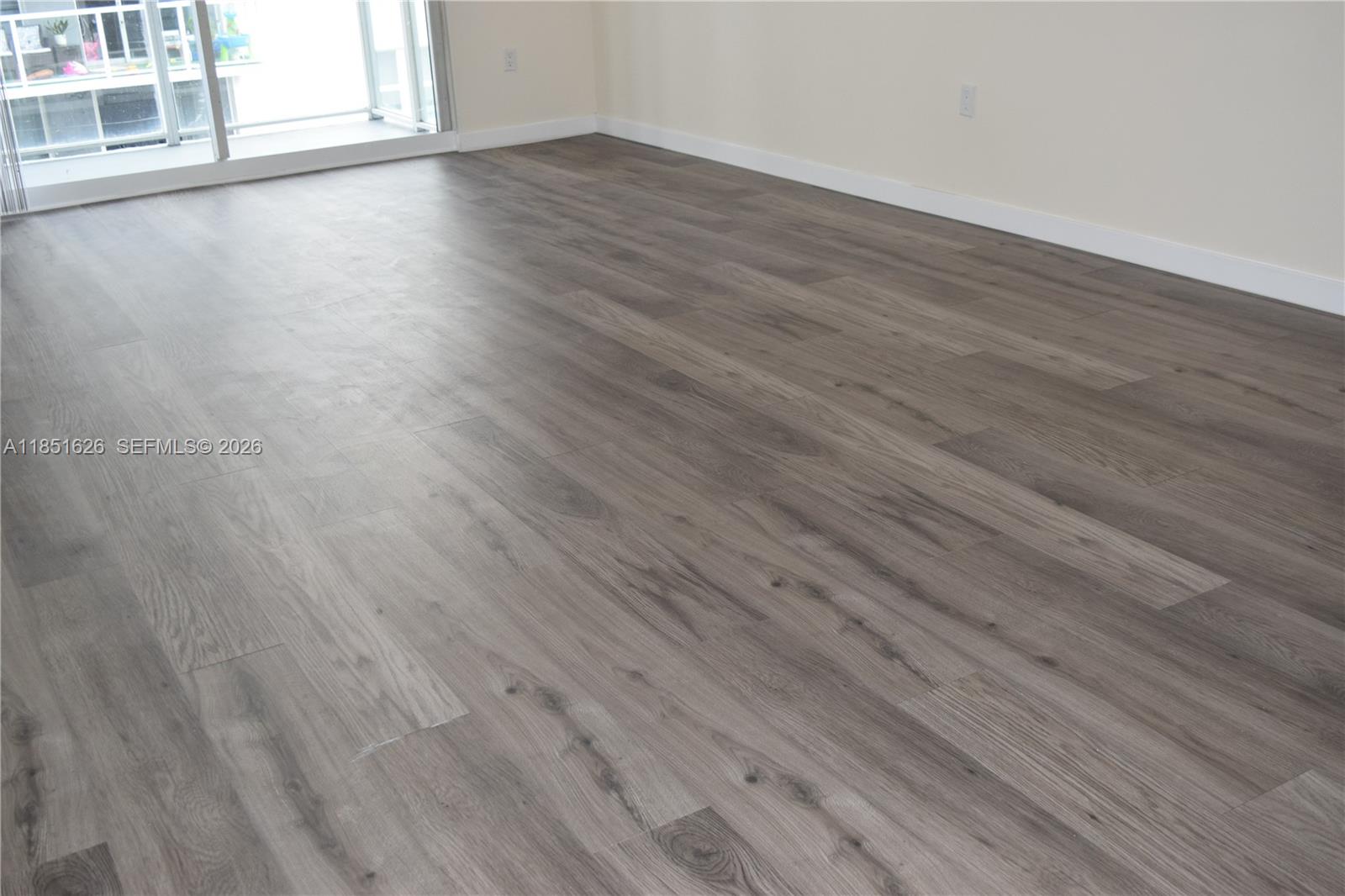 5091 Northwest 7th Street, Unit 711 Miami, FL 33126 - Photo 12 of 72 a view of a livingroom with wooden floor and window