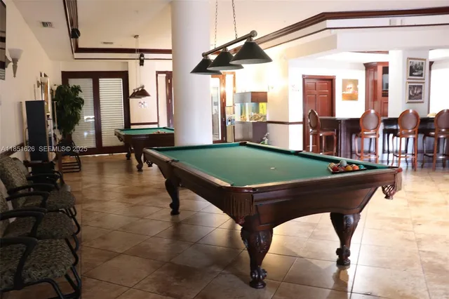 a room with pool table and windows
