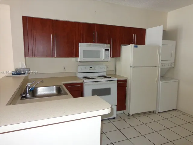 a kitchen with a refrigerator sink and cabinets