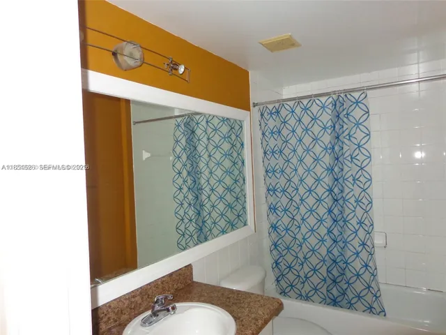 a bathroom with a shower curtain and a sink