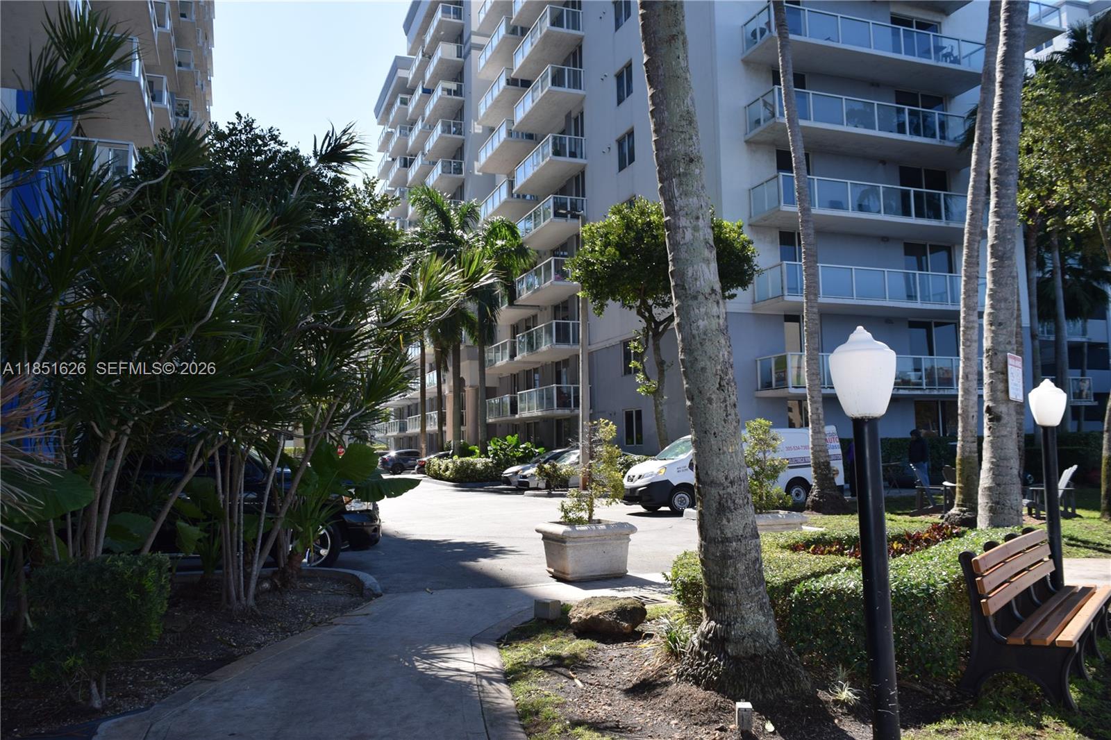 5091 Northwest 7th Street, Unit 711 Miami, FL 33126 - Photo 32 of 72 a front view of multi story residential apartment building with yard and outdoor seating
