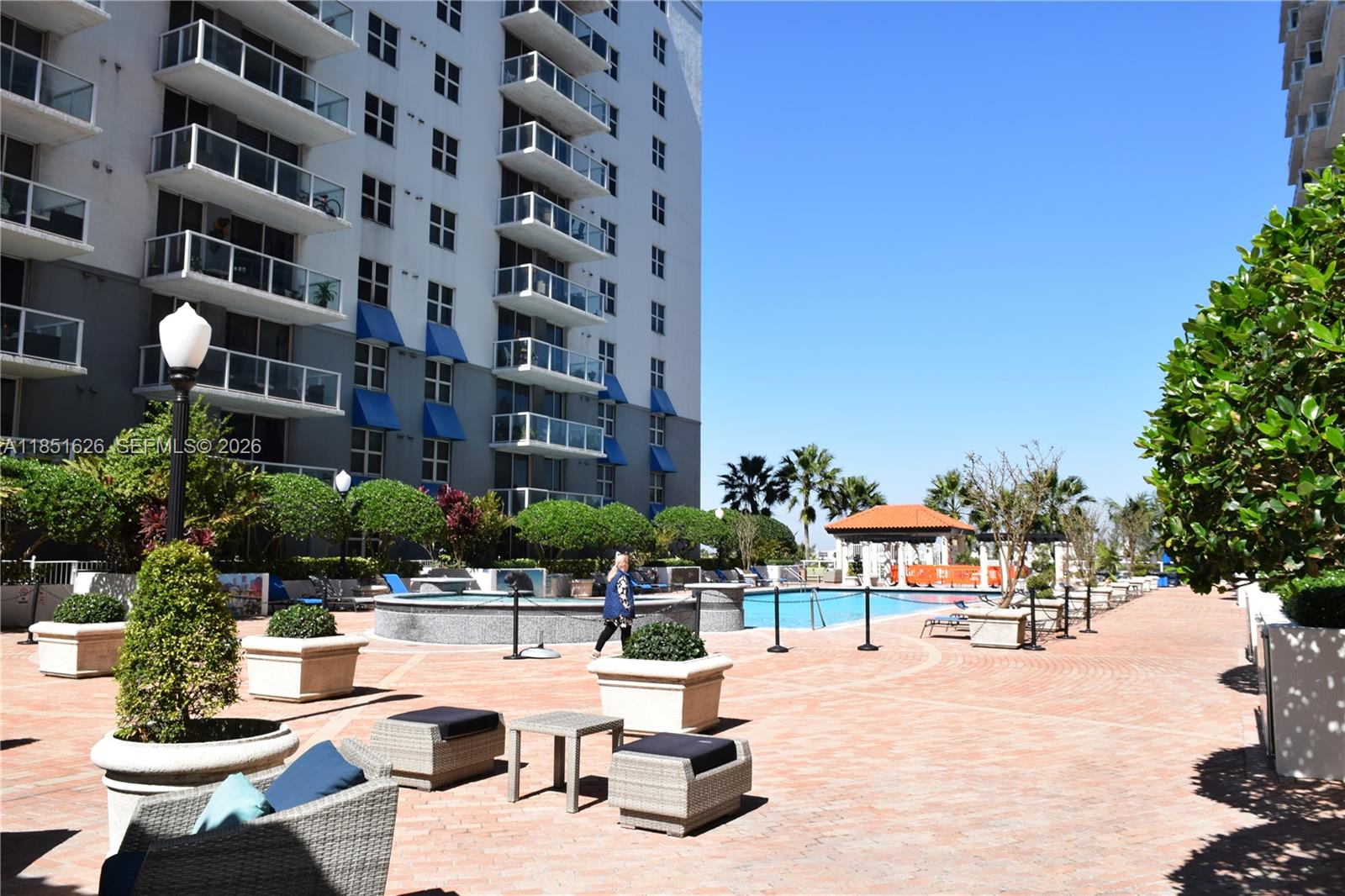 5091 Northwest 7th Street, Unit 711 Miami, FL 33126 - Photo 52 of 72 a swimming pool with outdoor seating and a potted plants