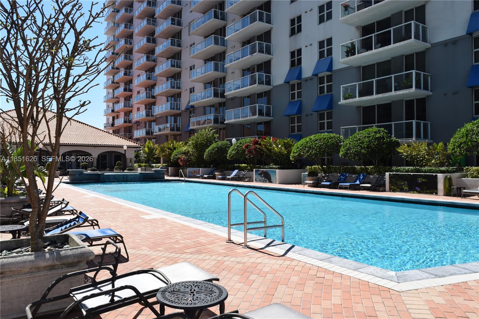5091 Northwest 7th Street, Unit 711 Miami, FL 33126 - Photo 54 of 72 a swimming pool with outdoor seating and yard