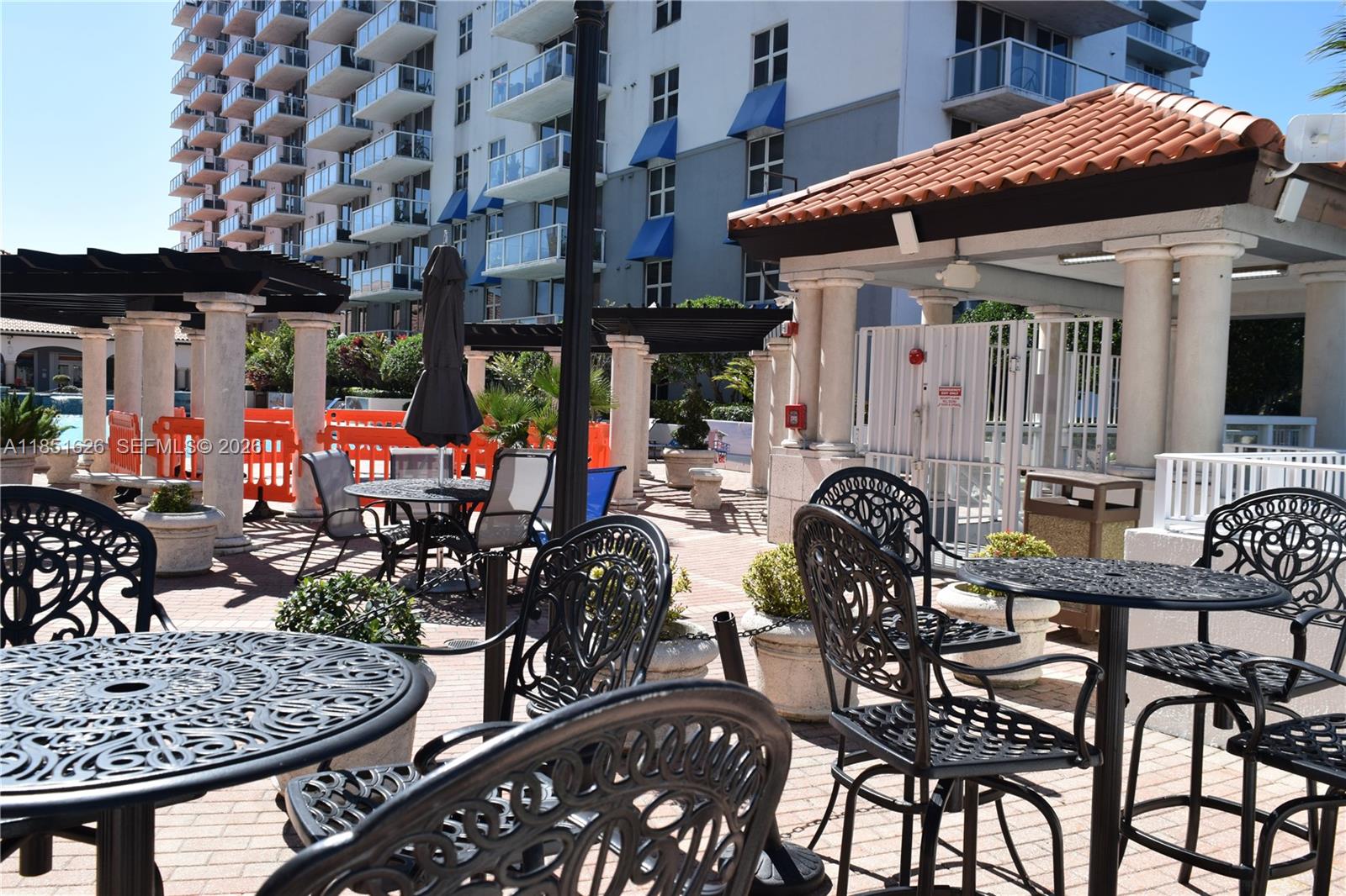 5091 Northwest 7th Street, Unit 711 Miami, FL 33126 - Photo 60 of 72 a view of a patio with table and chairs potted plants
