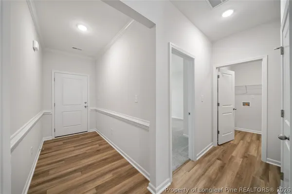 a view of a hallway with wooden floor and entryway