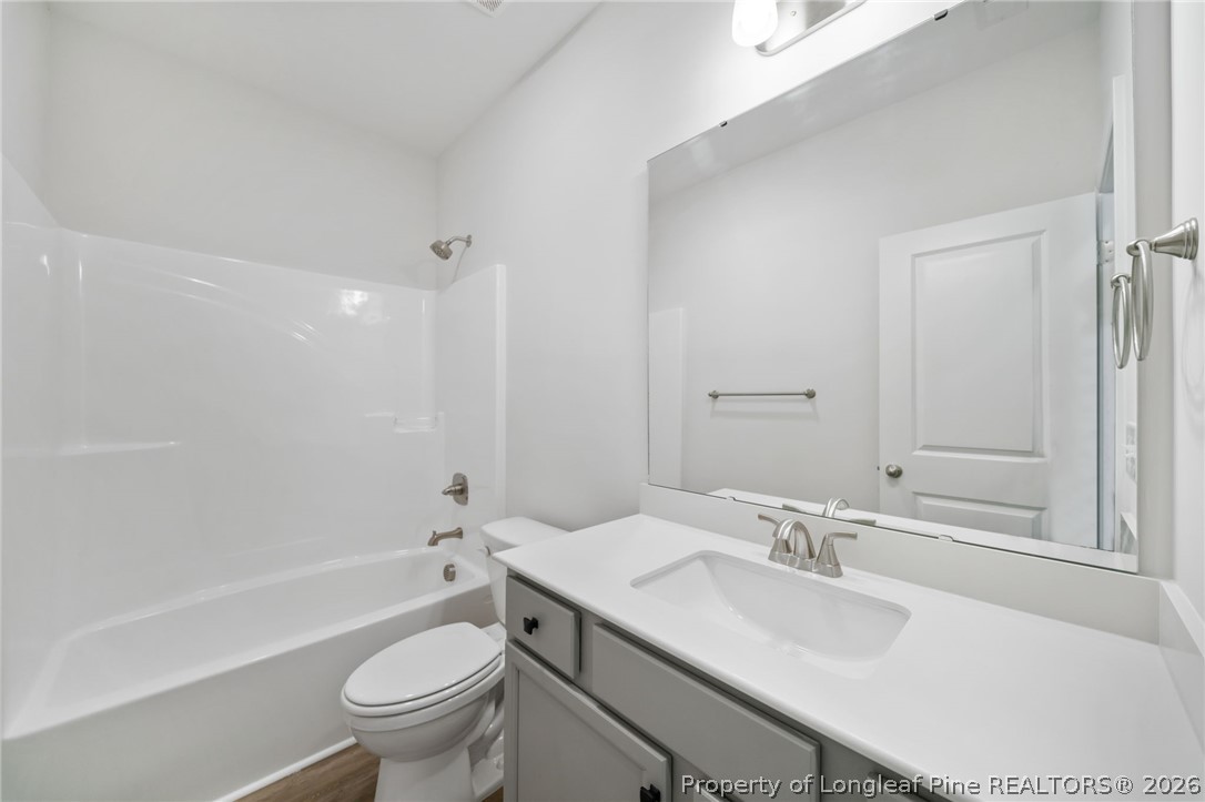 4047 Church Street Wade, NC 28395 - Photo 17 of 30 a bathroom with a toilet a sink a mirror a bathtub and vanity
