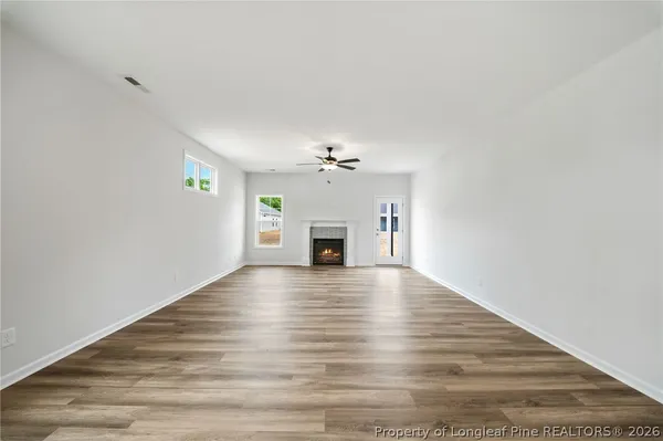 a view of empty room with wooden floor and fireplace