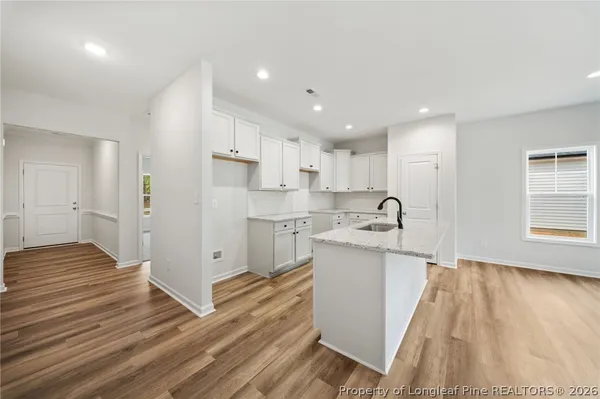 a view of a kitchen with wooden floor and electronic appliances