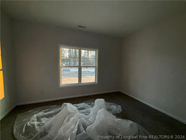 a bed sitting in a bedroom next to a window