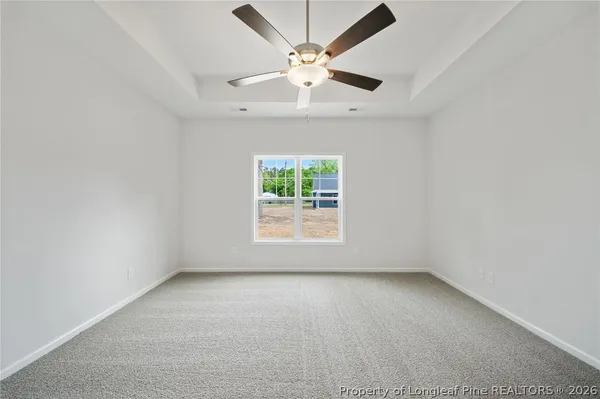 an empty room with a window and a fan