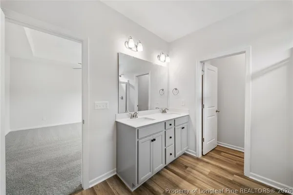a spacious bathroom with a granite countertop sink a mirror and a shower