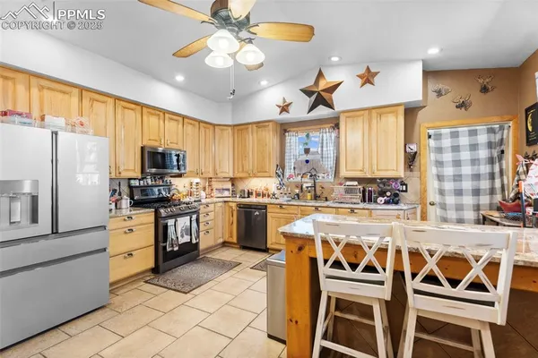a kitchen with a chandelier a dining table and stainless steel appliances