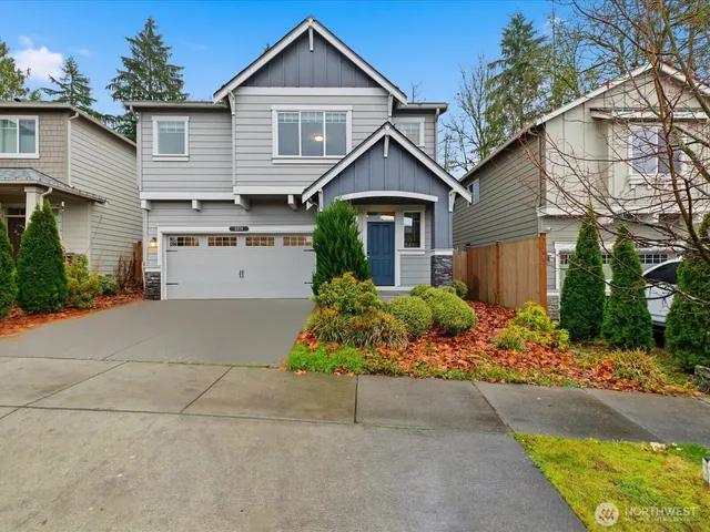 a front view of a house with a yard and potted plants