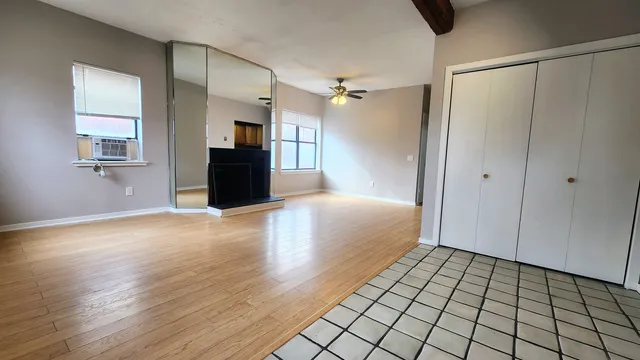 a view of a big room with wooden floor and a bathroom