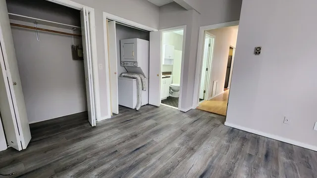 an empty room with wooden floor and a bathroom