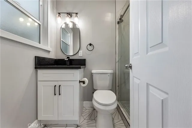 a bathroom with a toilet a sink and mirror