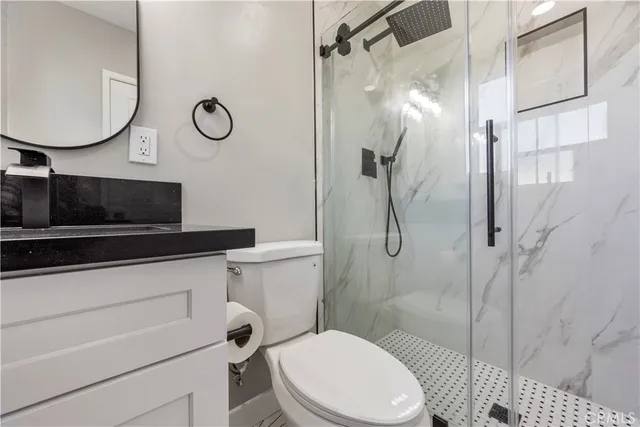 a bathroom with a toilet a sink and mirror