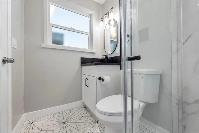 a bathroom with a toilet a sink and mirror