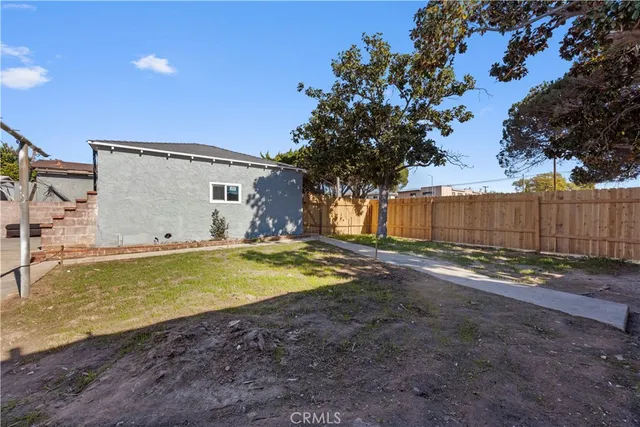 a view of a house with backyard and tree