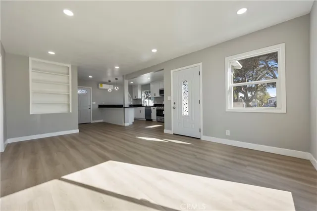 a view of empty room with wooden floor and windows