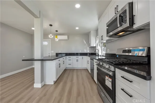 a kitchen with stainless steel appliances granite countertop a stove a sink and a refrigerator