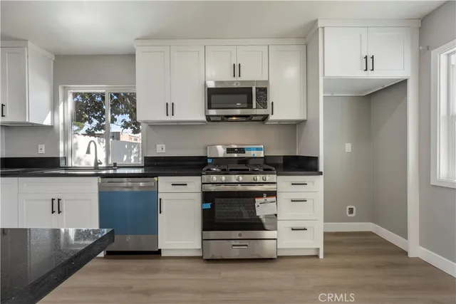 a kitchen with stainless steel appliances a stove a microwave and cabinets