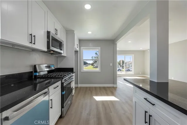 a kitchen with stainless steel appliances granite countertop a sink stove and microwave