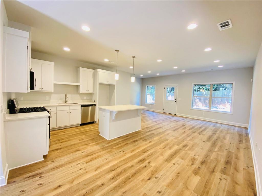 1099 North Village Drive Decatur, GA 30032 - Photo 5 of 23 a large kitchen with kitchen island a sink a stove a oven with a dining table and chairs