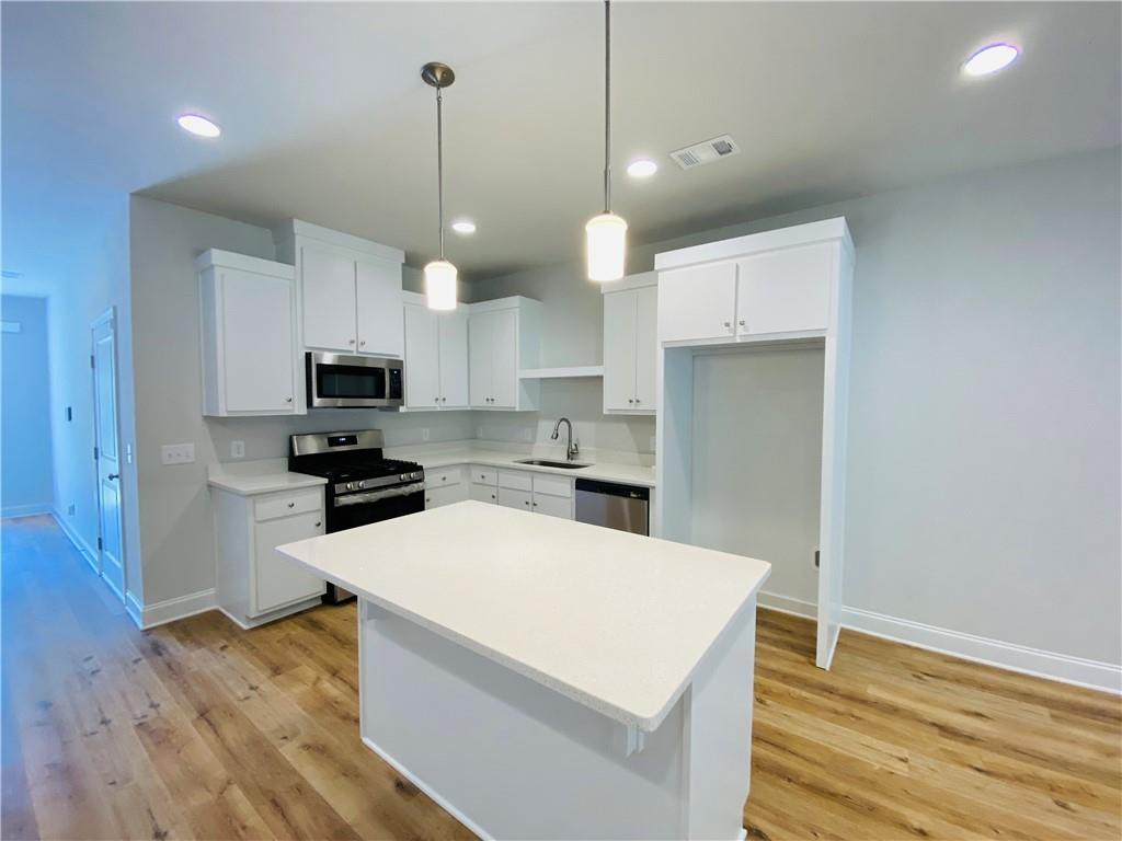 1099 North Village Drive Decatur, GA 30032 - Photo 9 of 23 a kitchen with wooden floor and white appliances