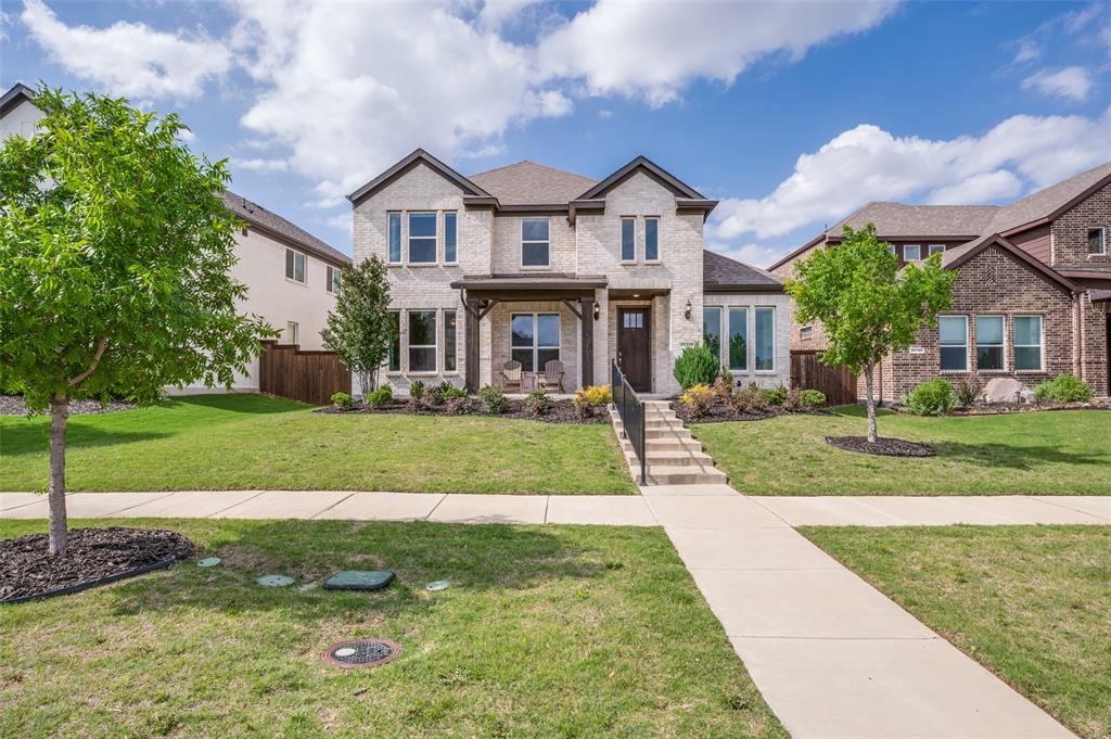 15718 Pheasant Wood Road Frisco, TX 75035 - Photo 1 of 1 Traditional-style residence featuring a light-colored brick exterior, dark trim accents, and a covered front porch with dark columns