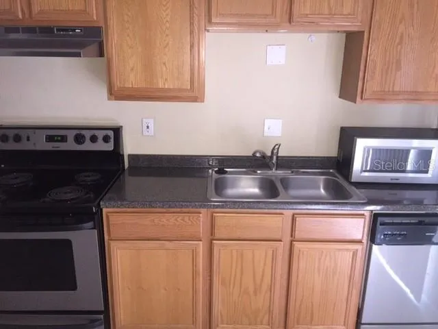 a kitchen with stainless steel appliances granite countertop a stove and a sink