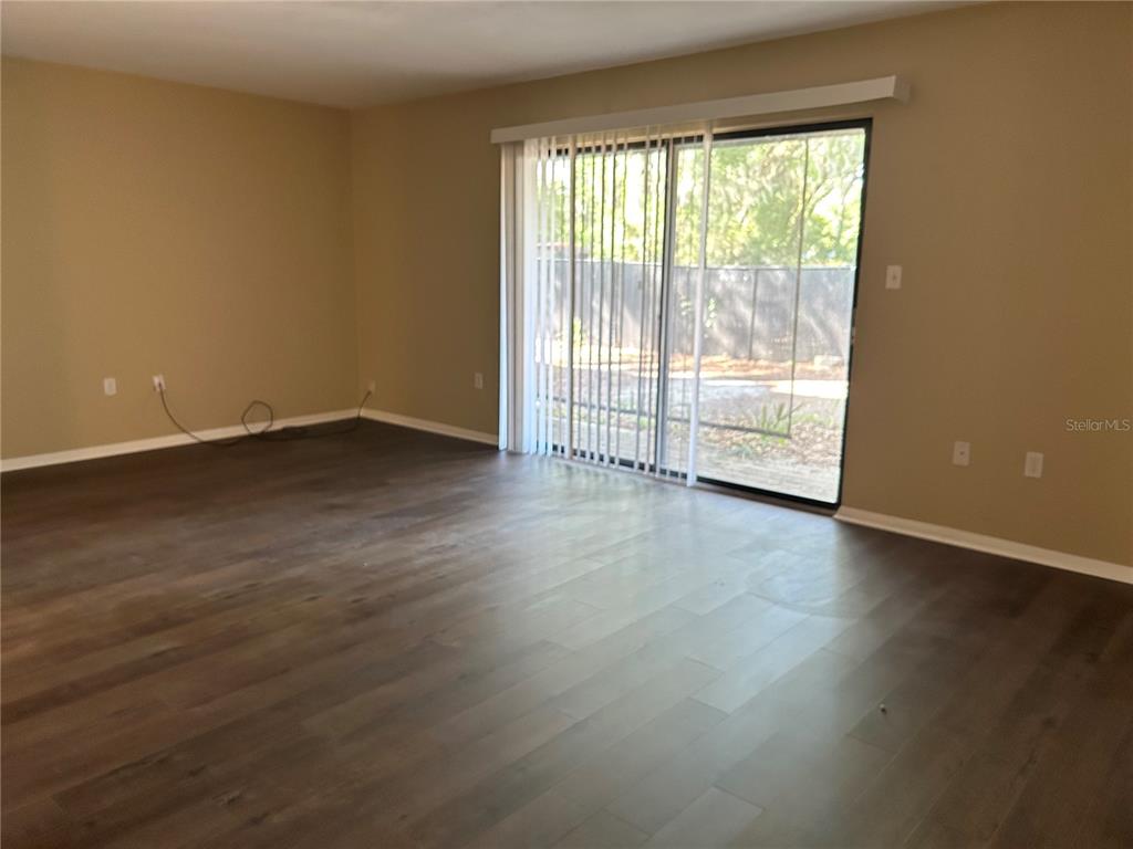 507 Northwest 39th Road, Unit 310 Gainesville, FL 32607 - Photo 7 of 18 a view of an empty room with wooden floor and a window
