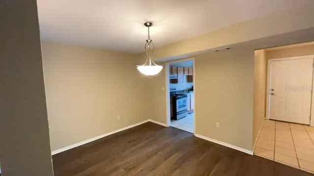 a view of a room with wooden floor and white walls