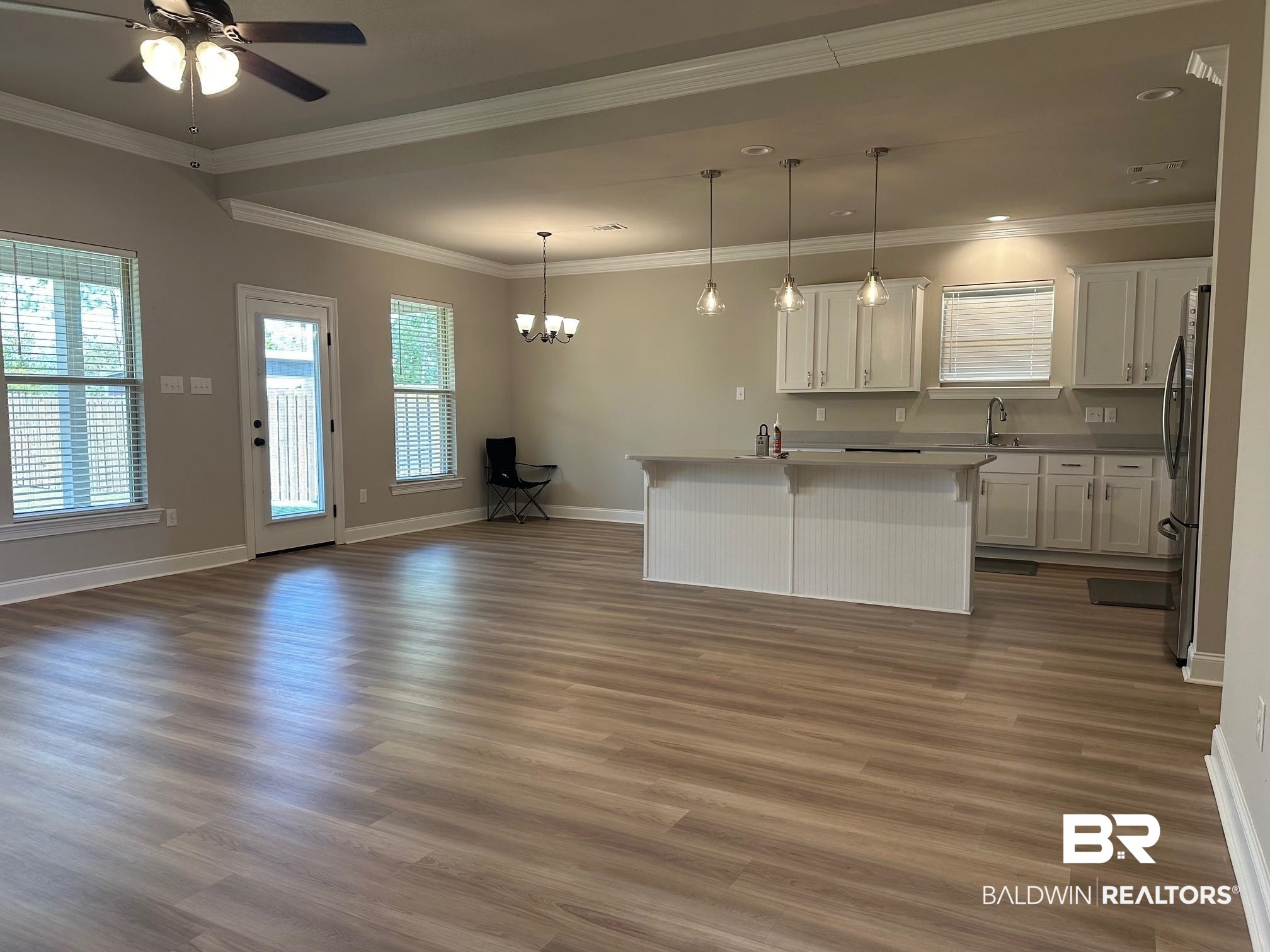 1009 Ruisseau Drive Foley, AL 36535 - Photo 14 of 55 Kitchen featuring dark hardwood / wood-style floors, a center island, pendant lighting, and white cabinetry
