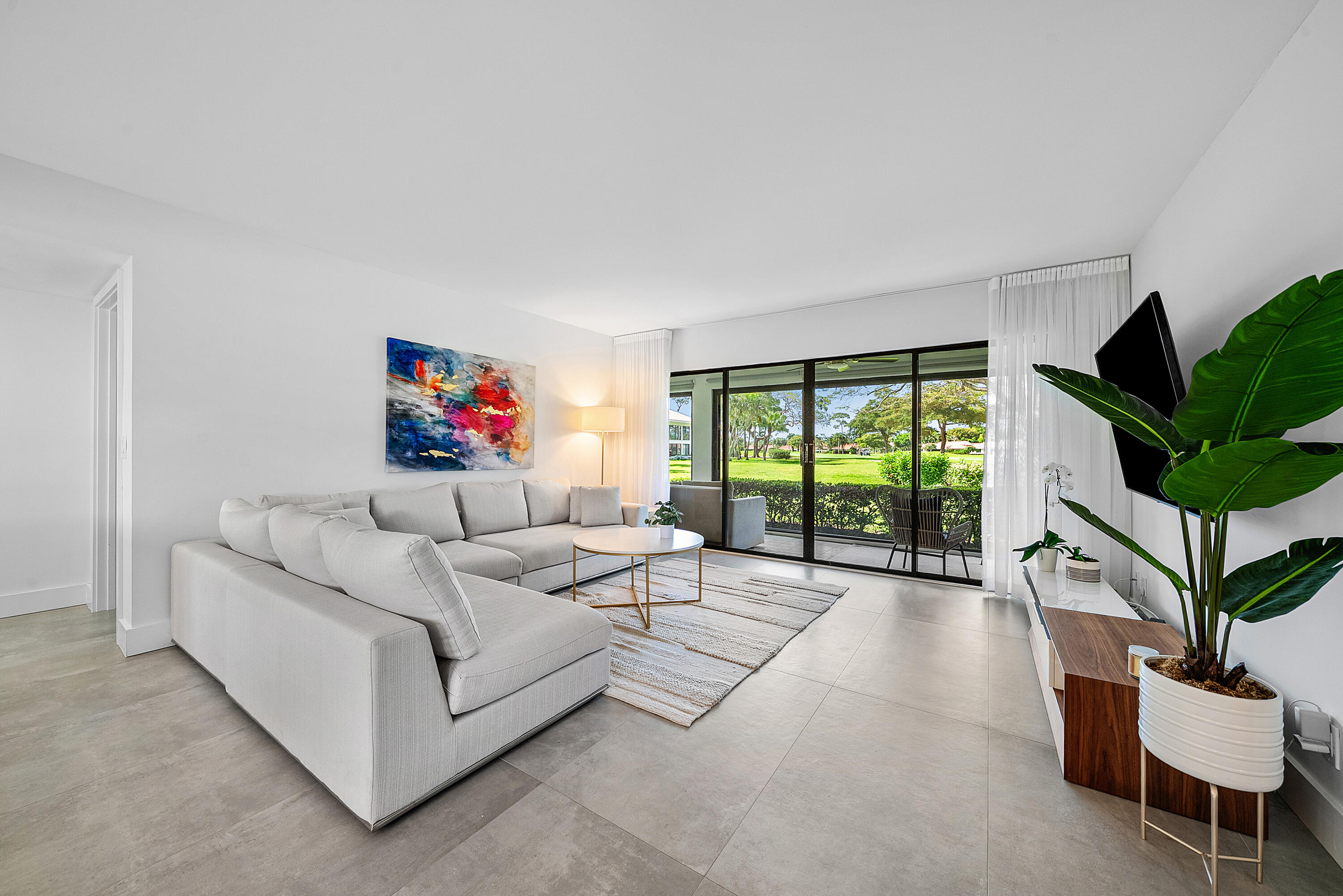 4116 North Quail Ridge Drive, Unit A Boynton Beach, FL 33436 - Photo 1 of 41 a living room with furniture a flat screen tv and a large window