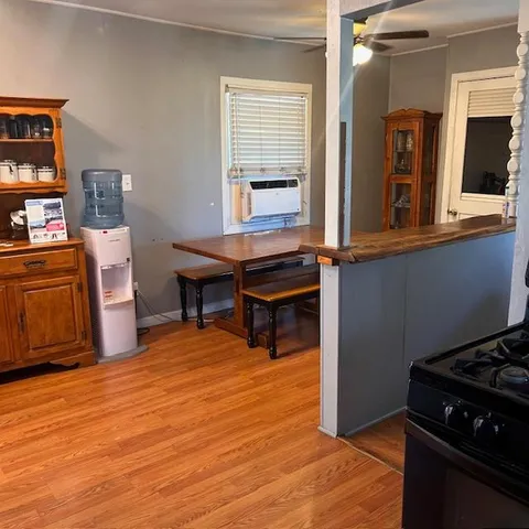 a kitchen with stainless steel appliances granite countertop a stove a refrigerator a sink and dishwasher with wooden floor