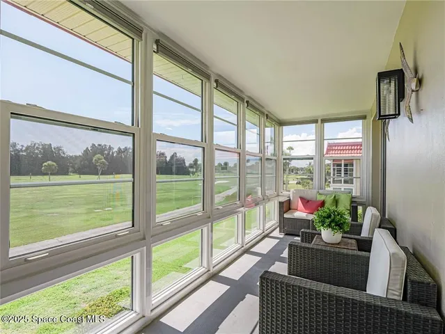 a living room with furniture and floor to ceiling windows
