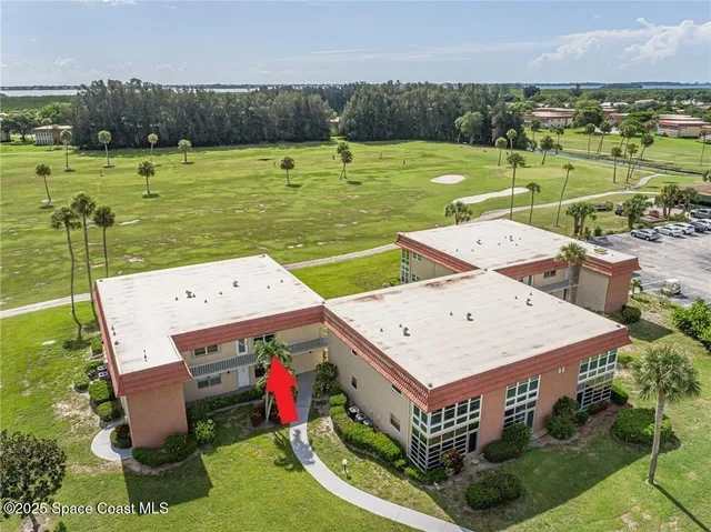 an aerial view of a house with swimming pool and yard