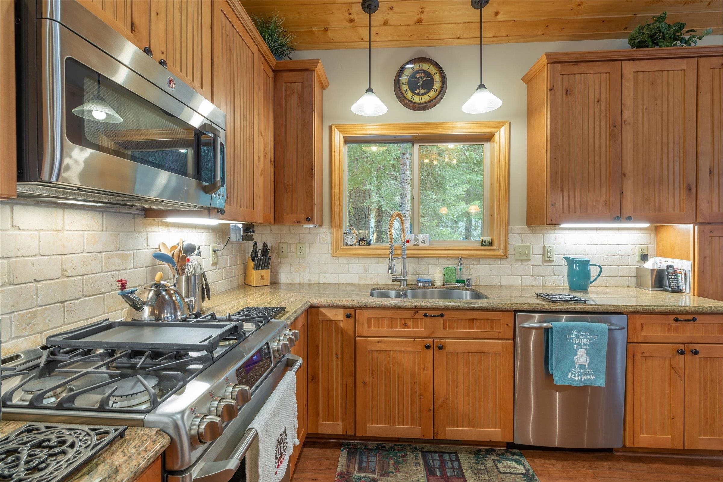 10308 Washoe Road Truckee, CA 96161 - Photo 6 of 21 a kitchen with a stove a sink a window and cabinets