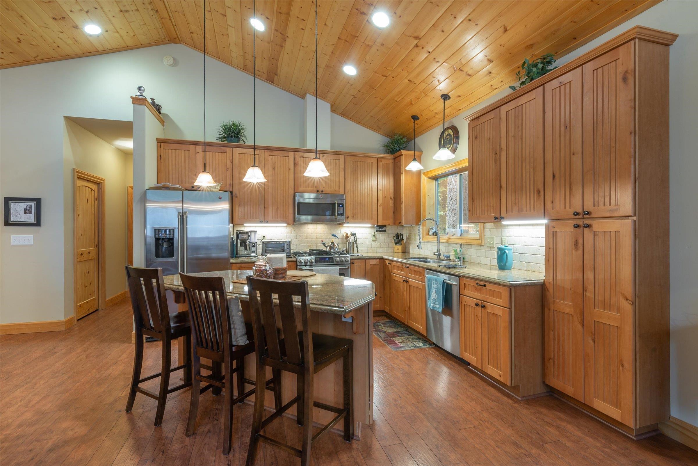 10308 Washoe Road Truckee, CA 96161 - Photo 7 of 21 a kitchen with a table chairs refrigerator and wooden cabinets
