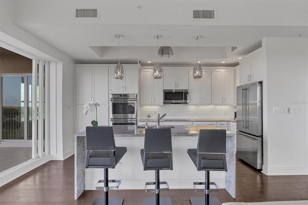 10530 Boardwalk Loop, Unit 601 Bradenton, FL 34202 - Photo 12 of 60 a kitchen with kitchen island white cabinets and stainless steel appliances