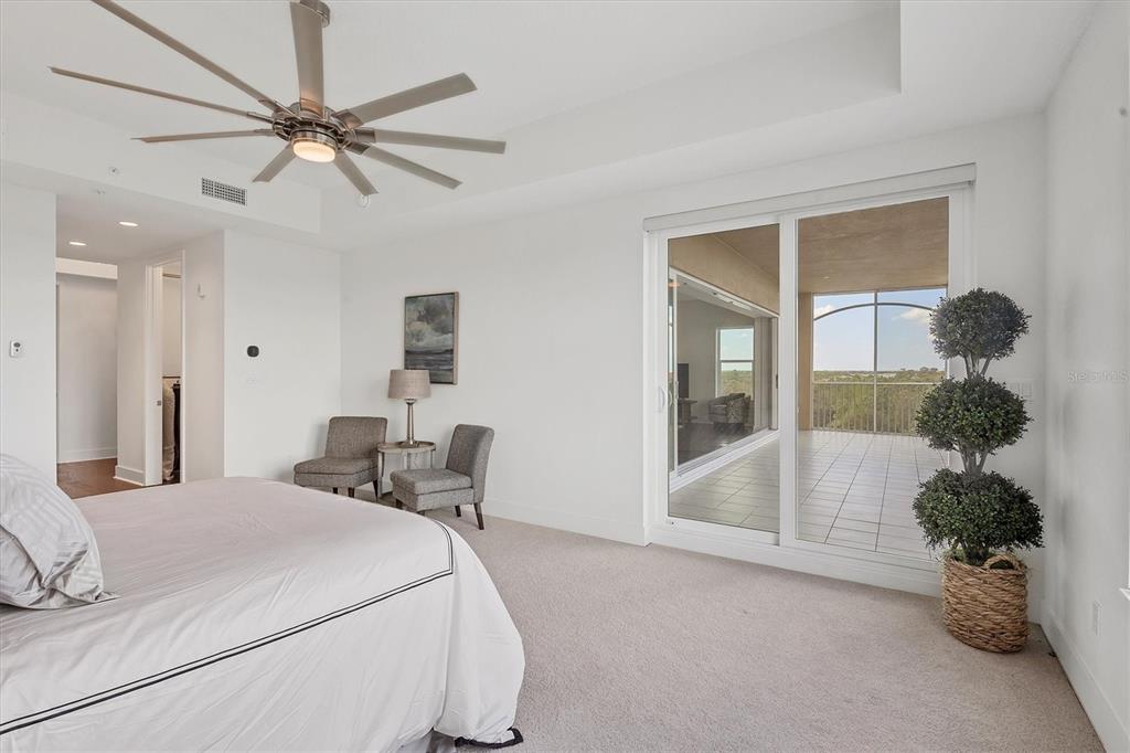 10530 Boardwalk Loop, Unit 601 Bradenton, FL 34202 - Photo 21 of 60 a bedroom with a large bed and a chandelier fan