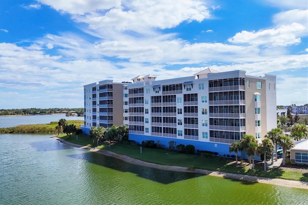 10530 Boardwalk Loop, Unit 601 Bradenton, FL 34202 - Photo 49 of 60 a view of a lake with a big yard and large trees